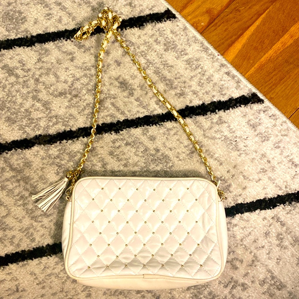 Quilted white leather bag with gold details.